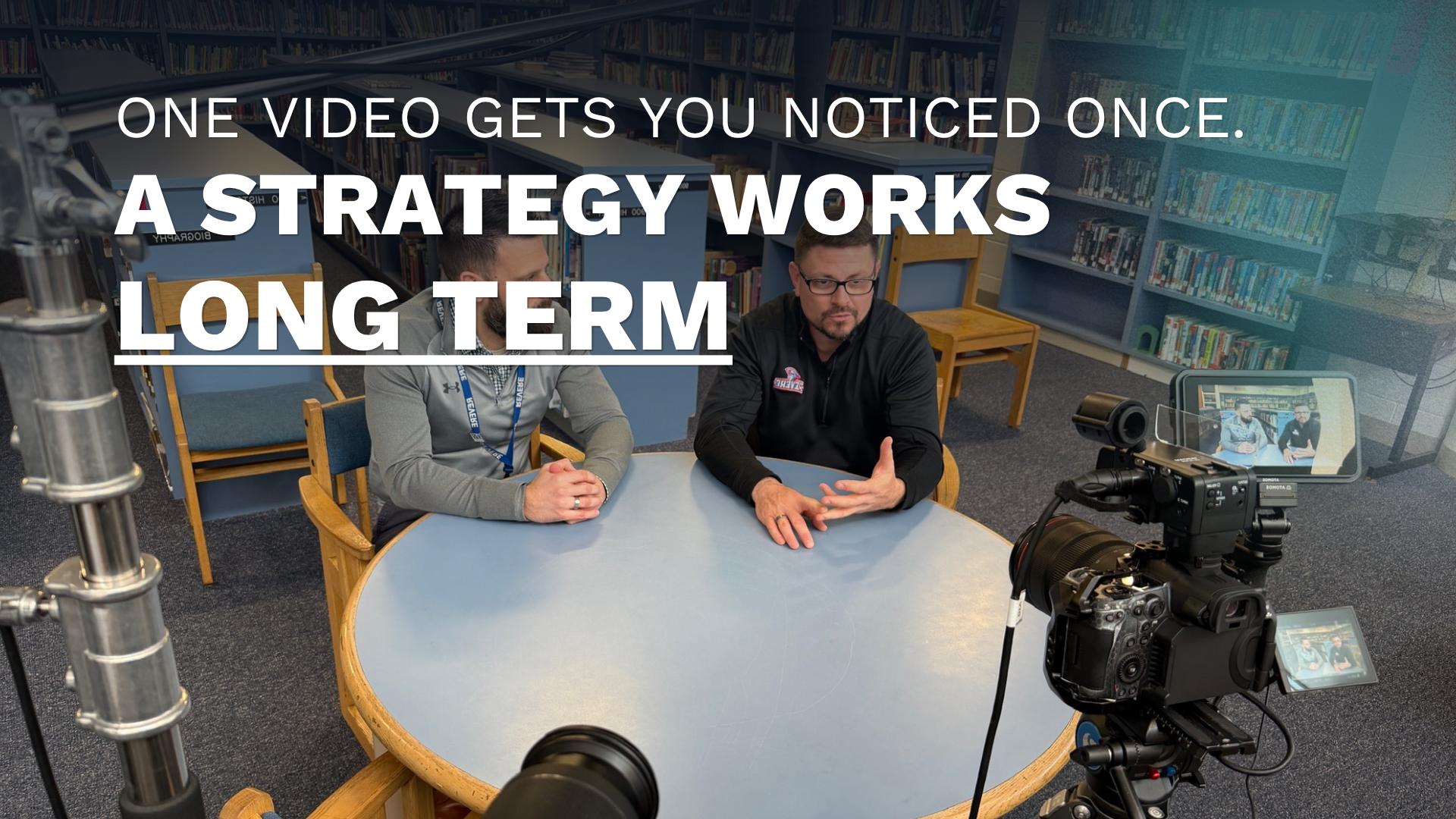 A Double Take Video camera operator filming 2 teachers at a table